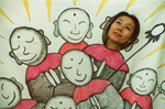Picture of Noriko Yamamoto with head on cutout painting of monks